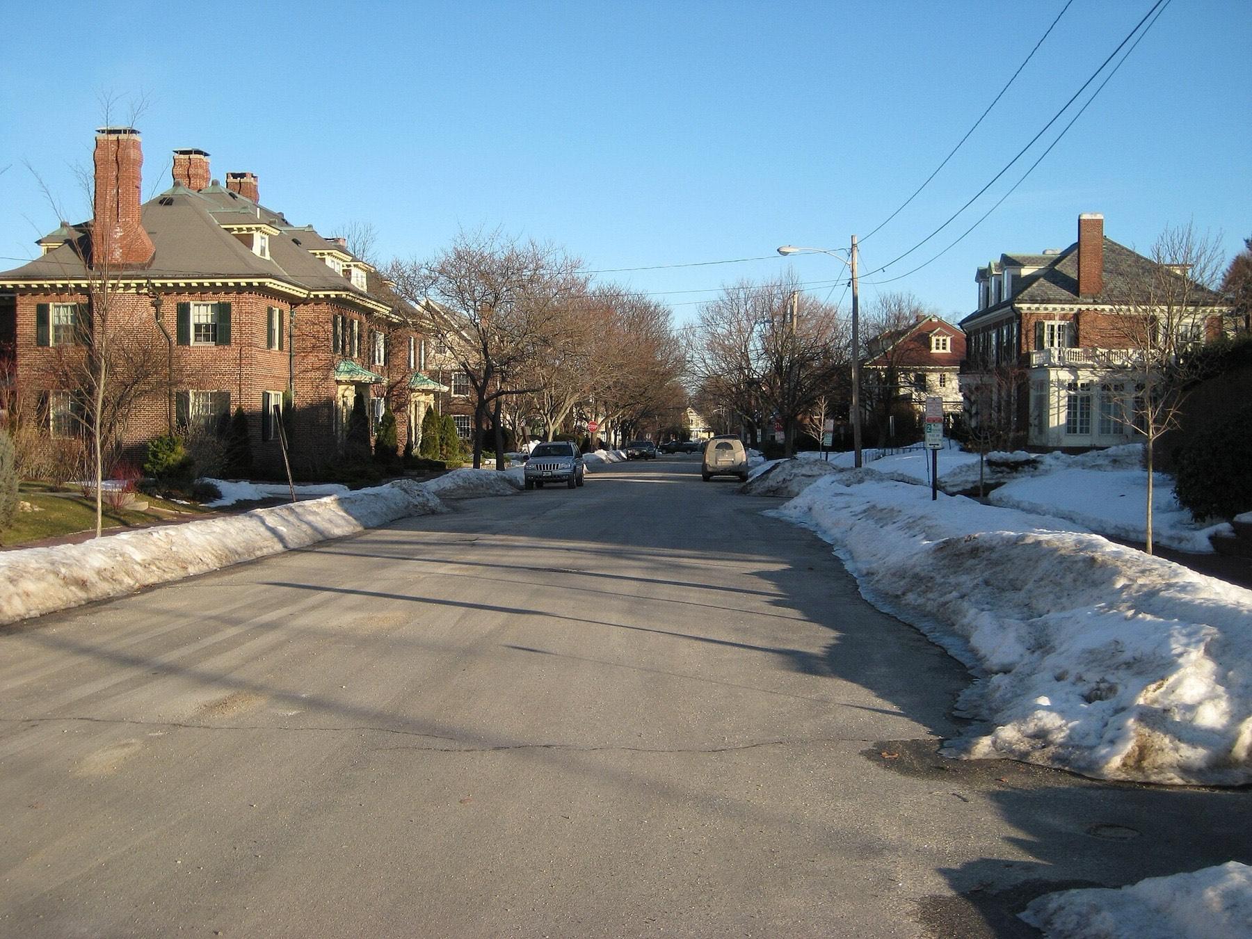 A quiet West End street in Portland, Maine, with brick houses and winter snow