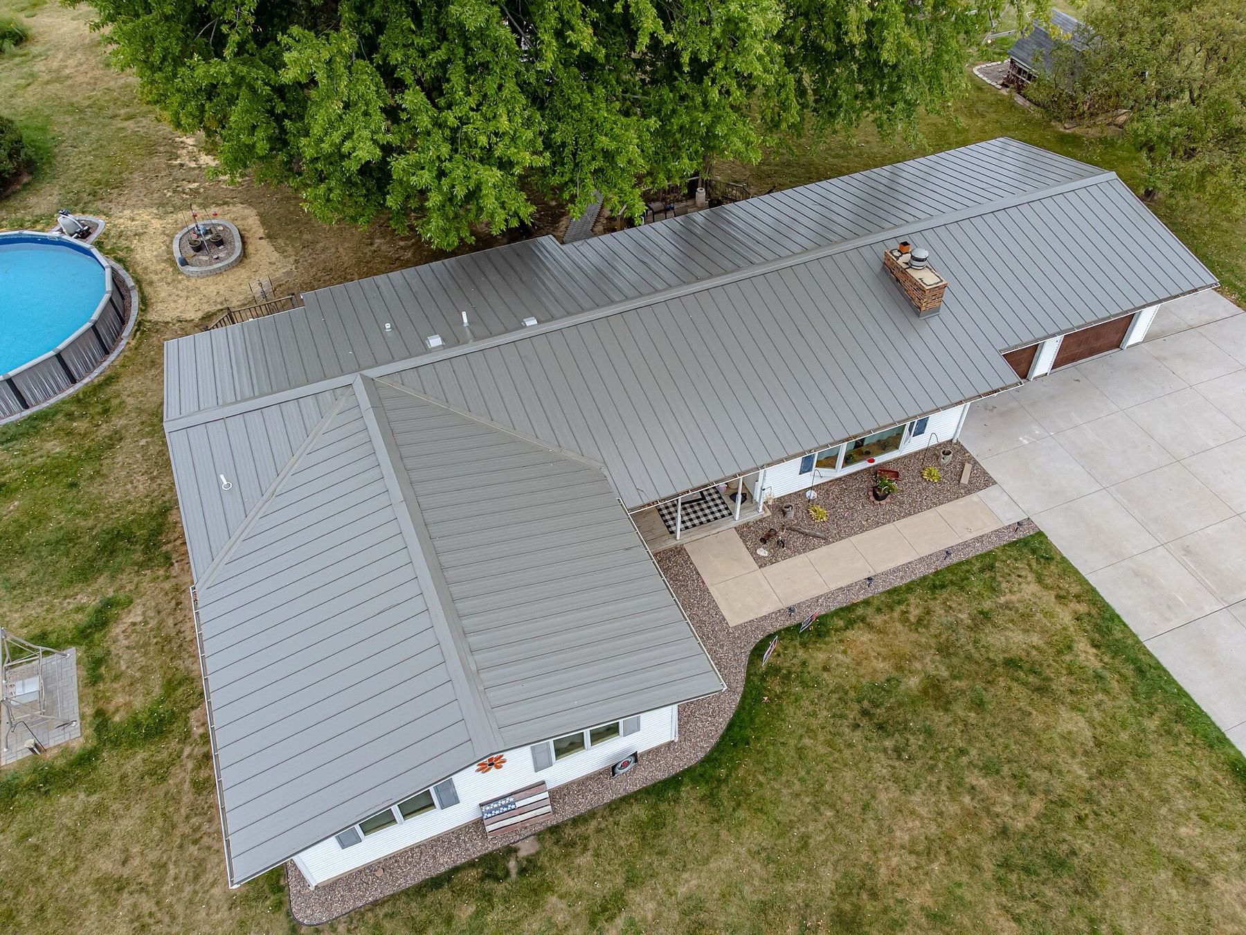 Aerial view of a house with a grey standing-seam metal roof